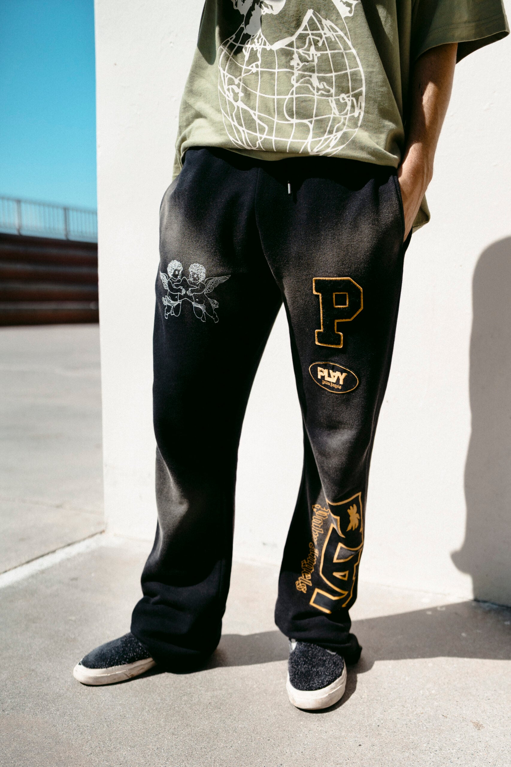 Black PLAY Palm Angels joggers with varsity patches