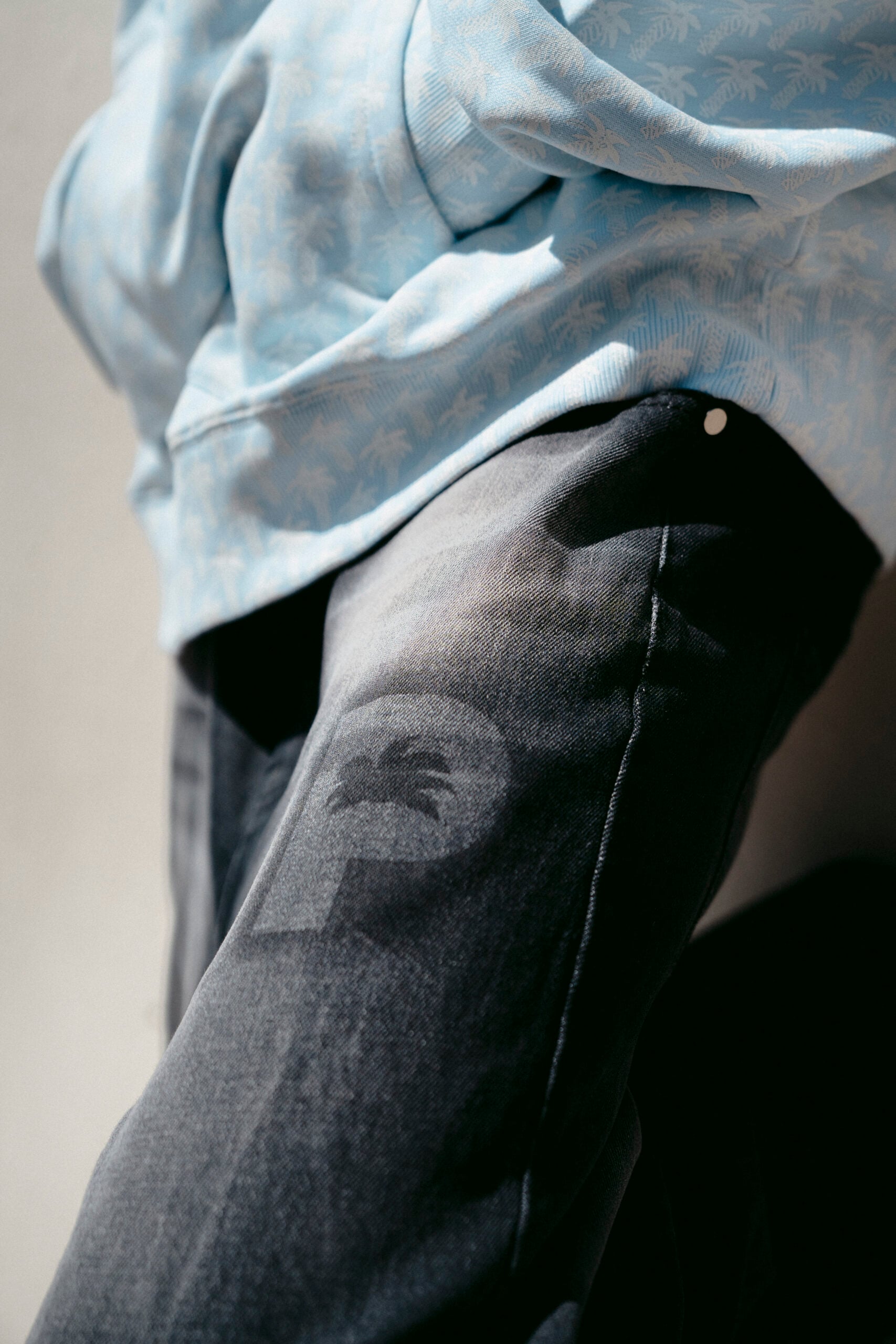 Close-up of a palm-print shirt and washed denim