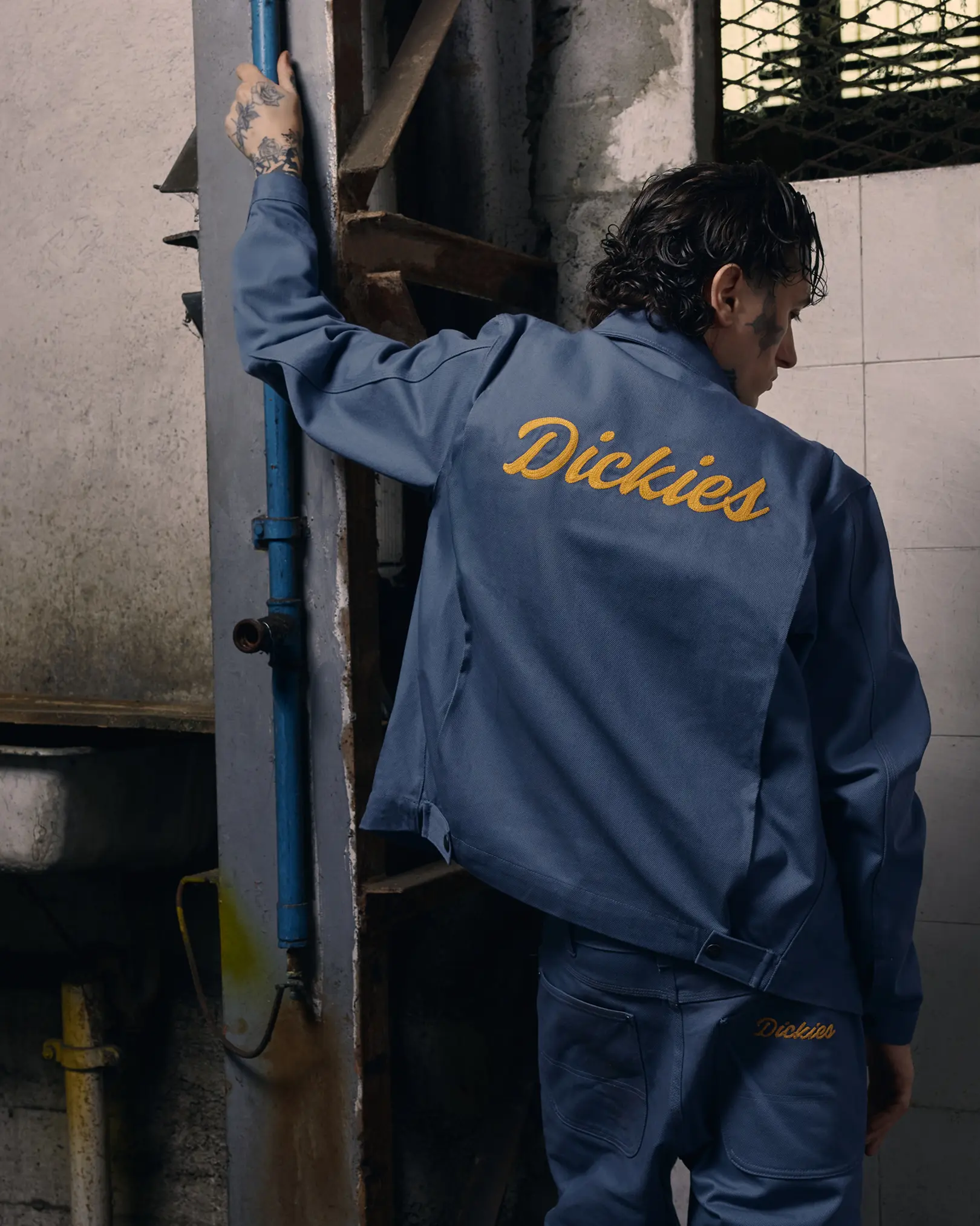 Man in a blue Dickies work jacket seen from behind