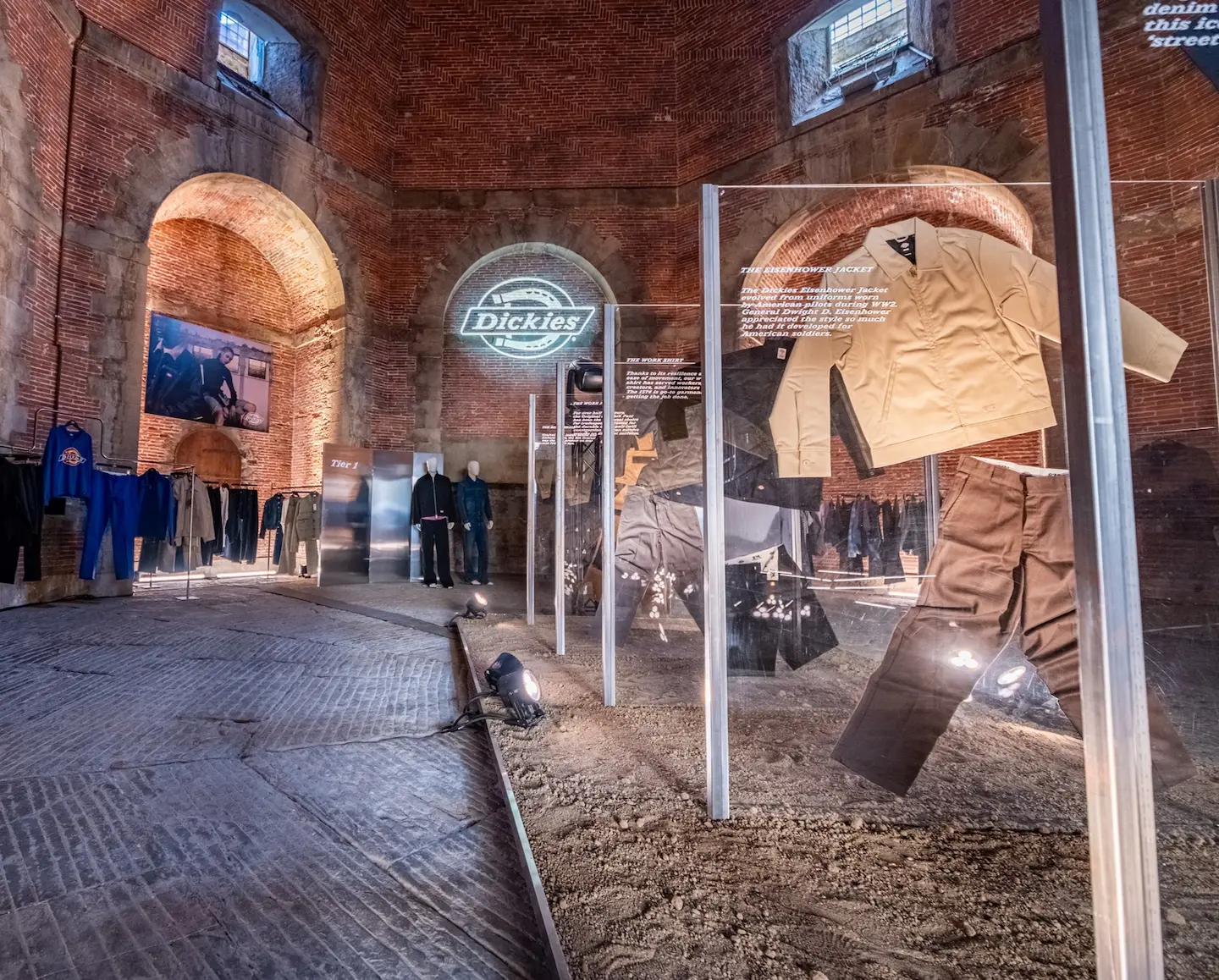 Dickies SS27 exhibition in a brick hall with a displayed Eisenhower jacket