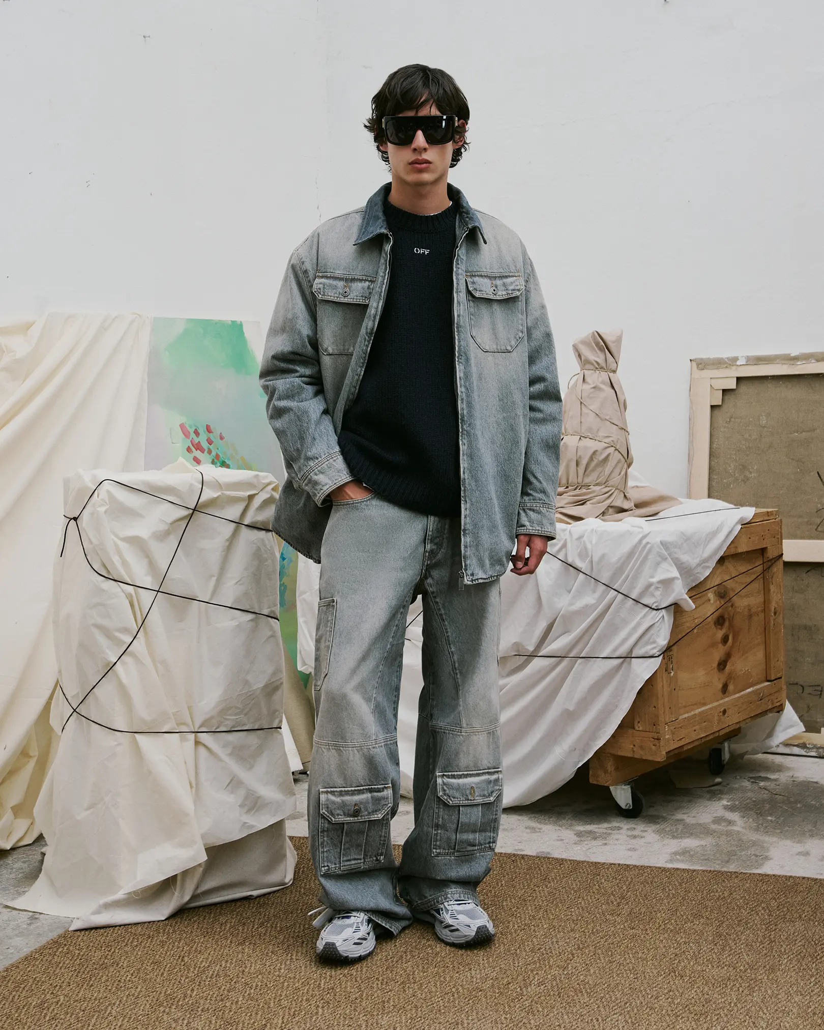 Model in a washed denim jacket and baggy cargo jeans in a studio