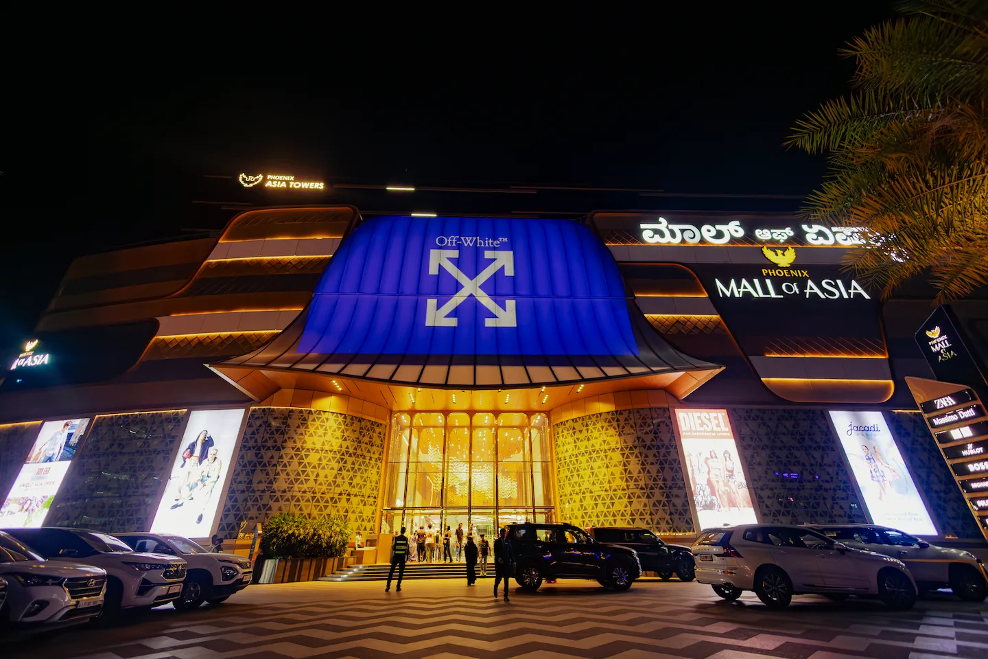 Phoenix Mall of Asia at night with an Off-White logo on the facade