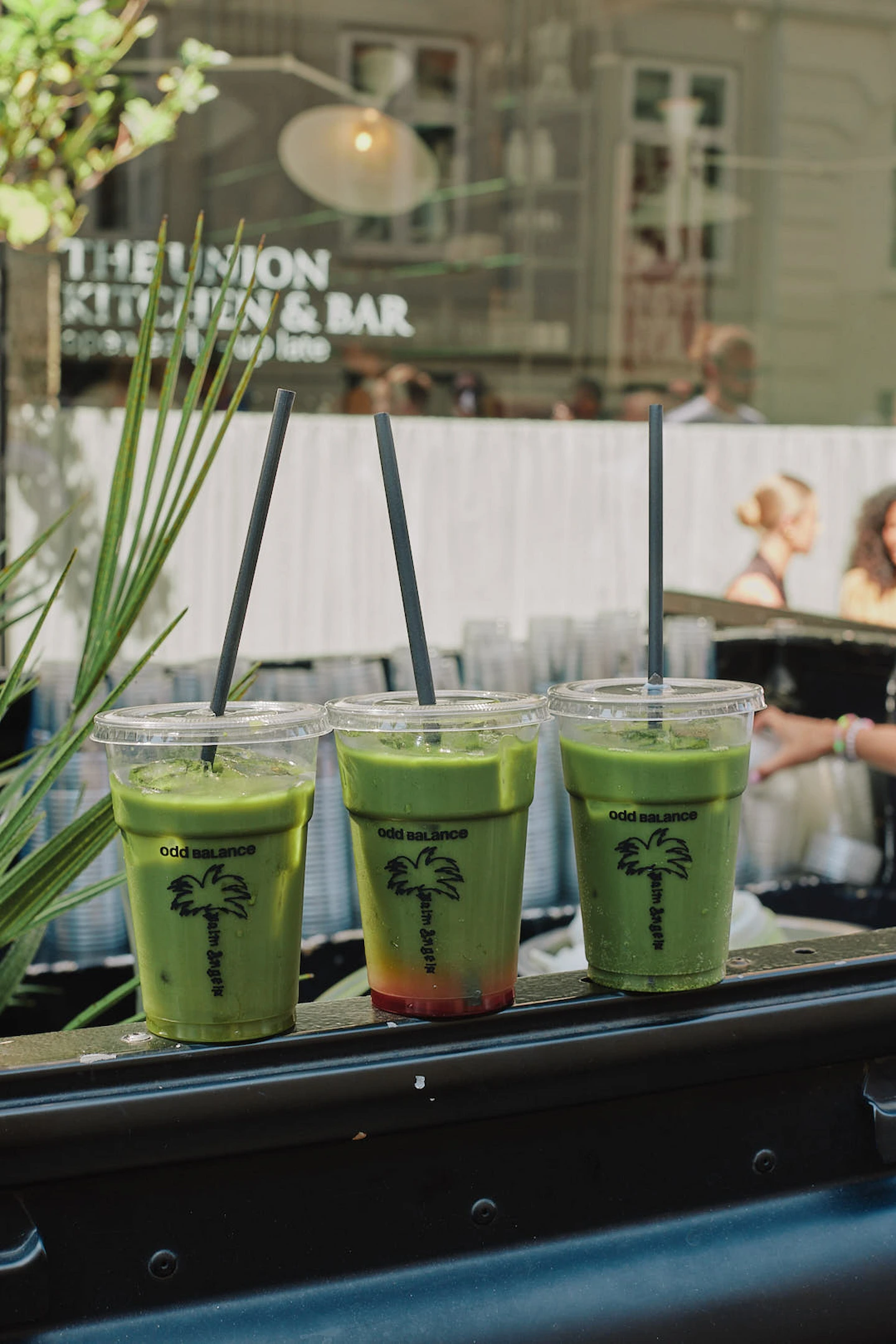 Three green Odd Balance smoothies with Palm Angels palm branding