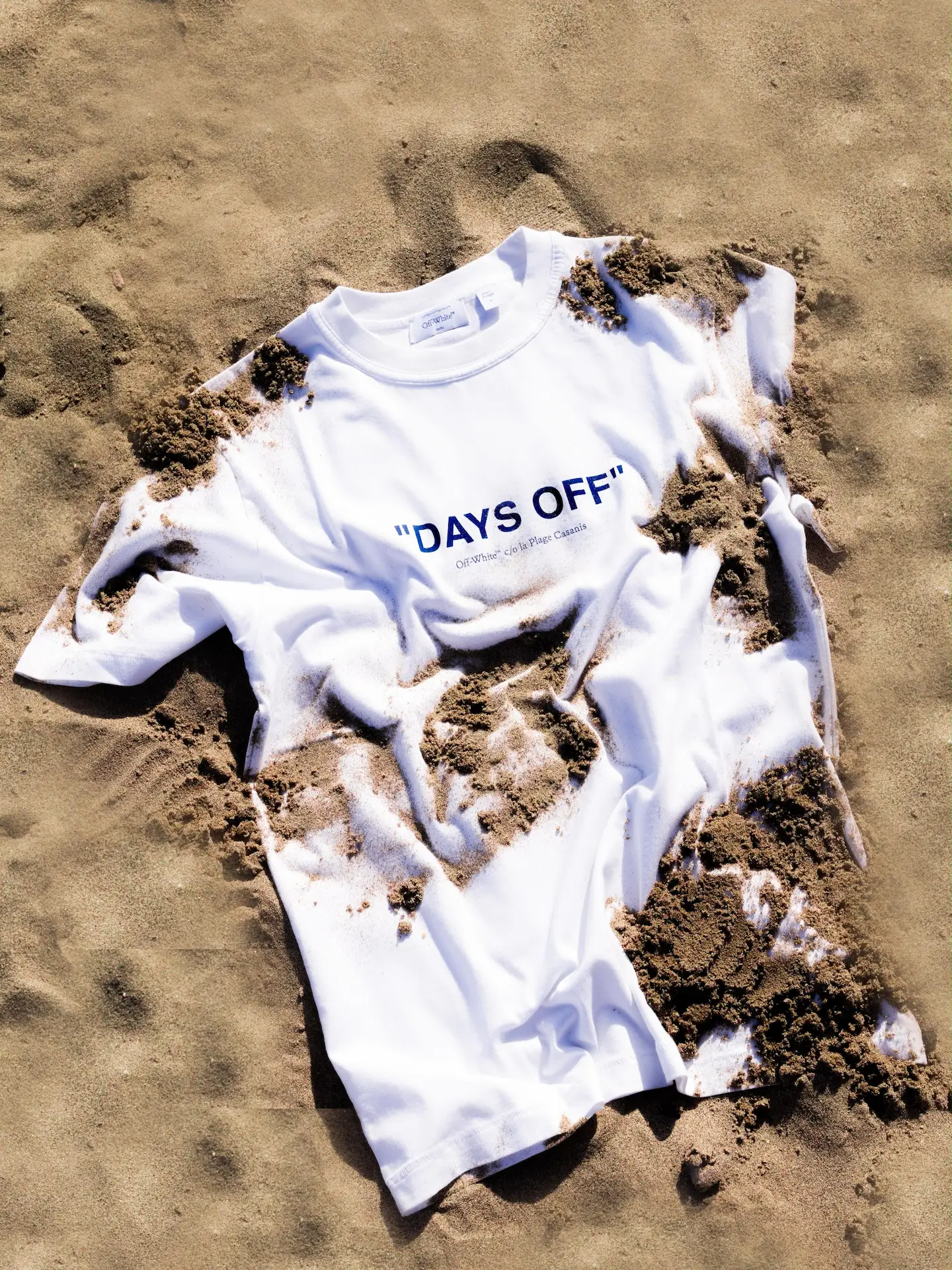 White "Days Off" Off-White t-shirt lying crumpled on sand