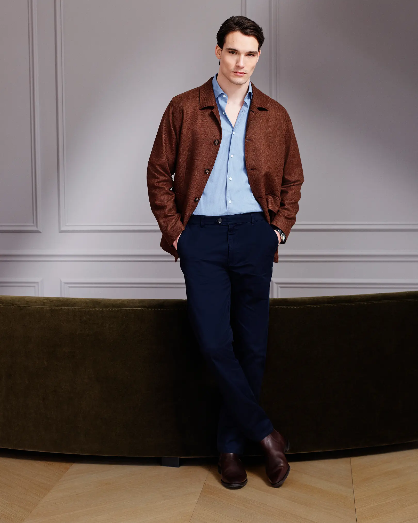 Man in a brown overshirt, blue shirt and navy trousers