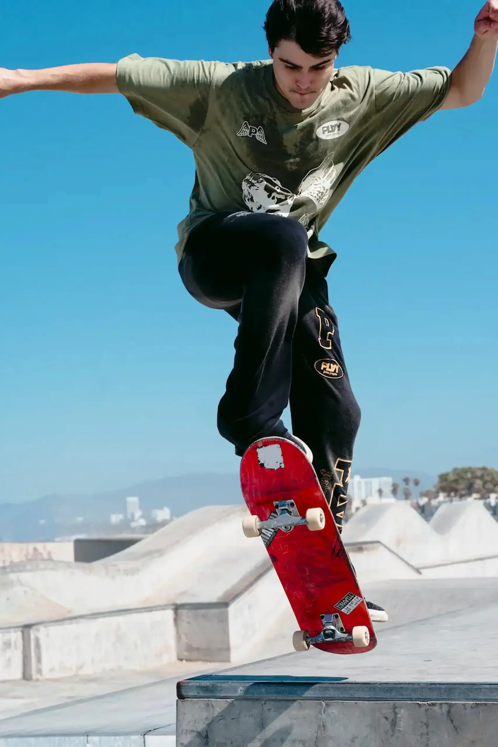 Skateboarder in PLAY apparel mid-trick at a skatepark