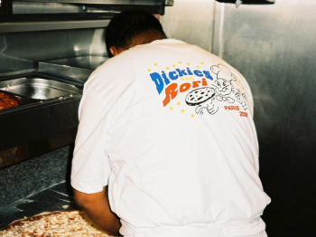 Pizzeria worker in a Dickies Rori t-shirt seen from behind, making pizza